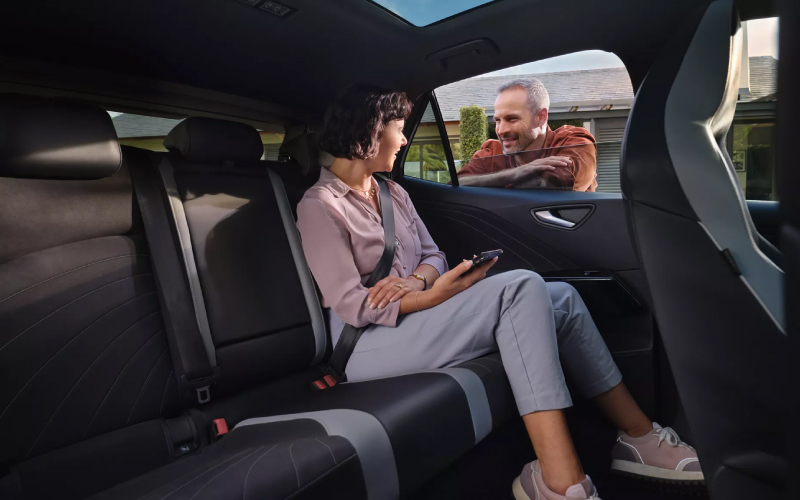 Volkswagen ID.3 interior with passenger speaking to man outside
